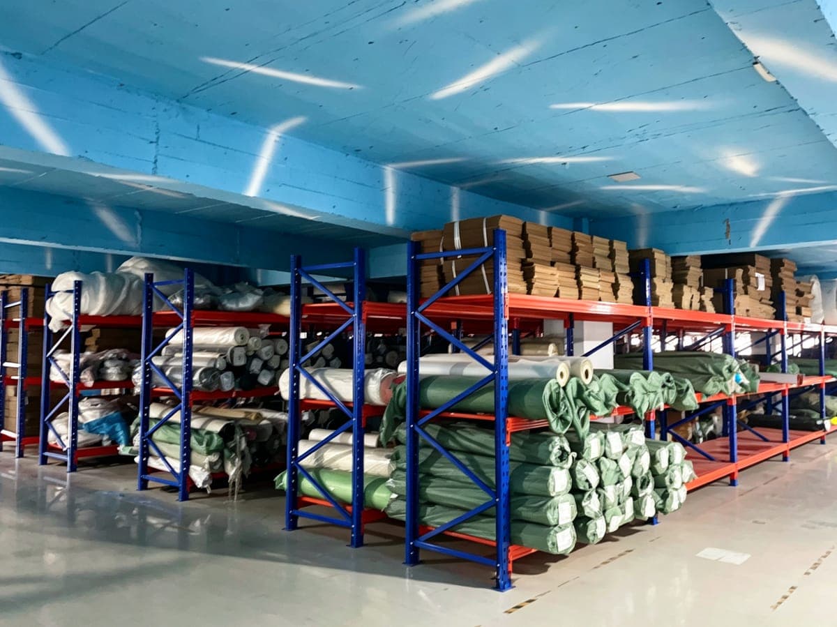 Material warehouse racks stocked with fabric and leather rolls