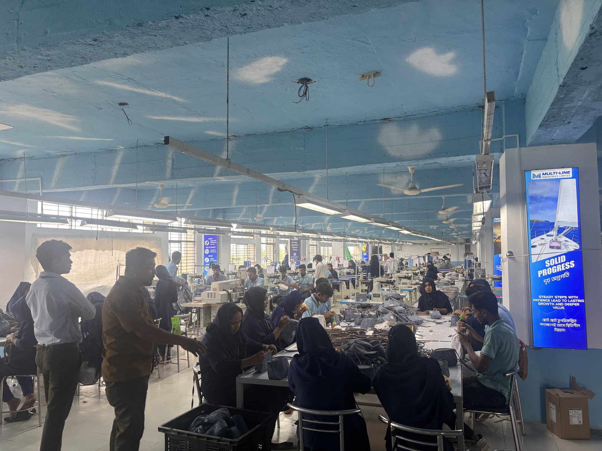 Sample-room workers around a long assembly table