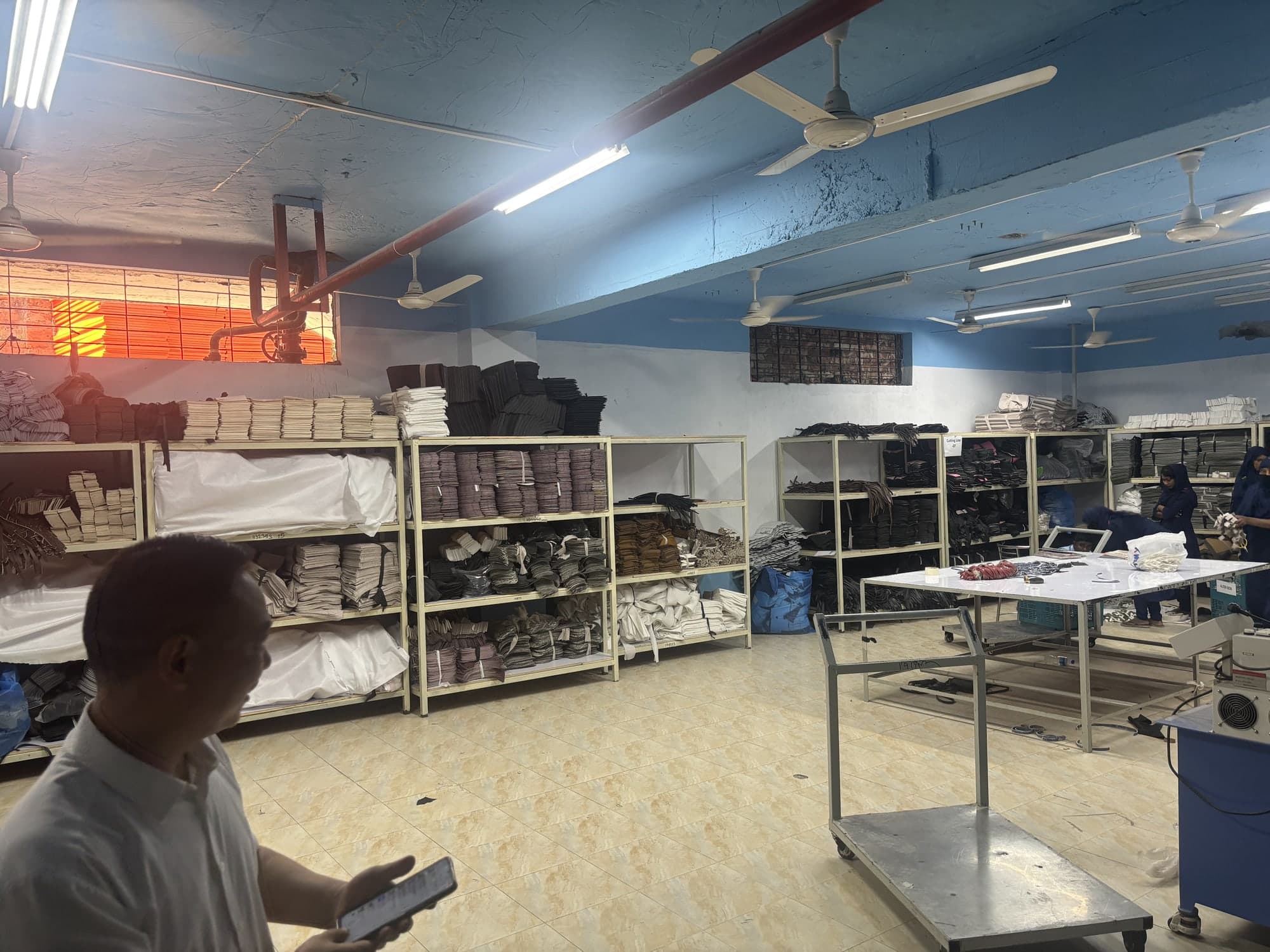 Materials warehouse shelving with rolls of canvas, leather, and packaging